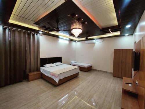 a bedroom with a bed and a television in it at M2 lambardaar in Dehradun