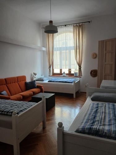 a living room with two beds and a couch at Apartament Deptak Sądecki in Nowy Sącz