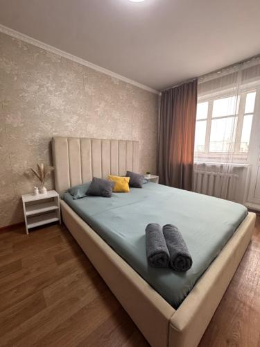 a bedroom with a large bed with two pillows at N40 Apartment in Pavlodar