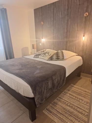 a bedroom with a large bed with a wooden wall at Au Vieux Séchoir in Prudhomat