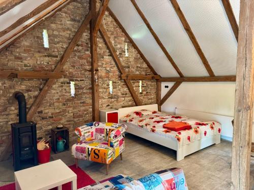 a attic room with two beds and a chair at Rotes Haus im Havelland in Phöben