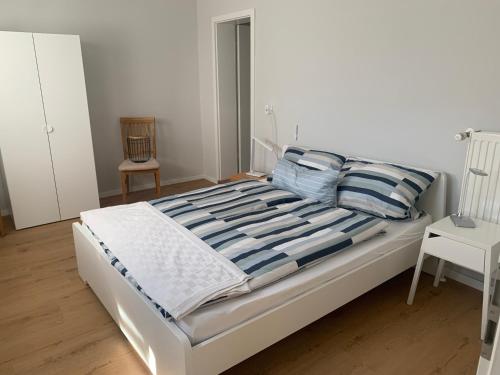 a bed with blue and white sheets and pillows at Eifelliebe in Bergweiler