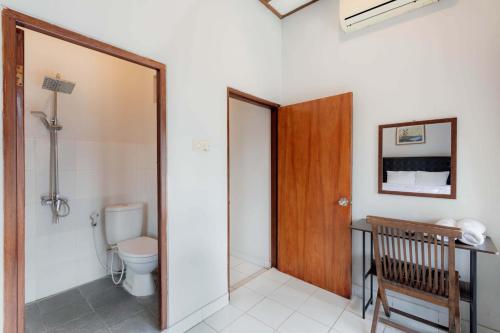 a bathroom with a toilet and a wooden door at Agni Homestay in Yogyakarta