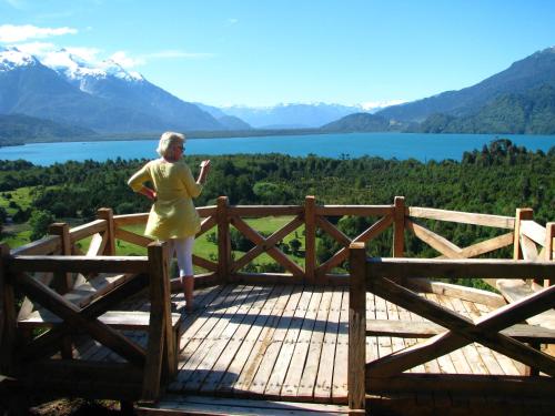 a woman standing on a wooden bridge with a view of a lake at Yelcho en la Patagonia in Chaitén