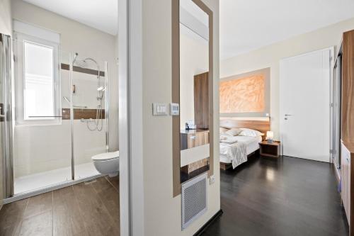 a bathroom with a toilet and a bed in a room at Modern Rooms Villa Oasiss by Istrabook in Pula