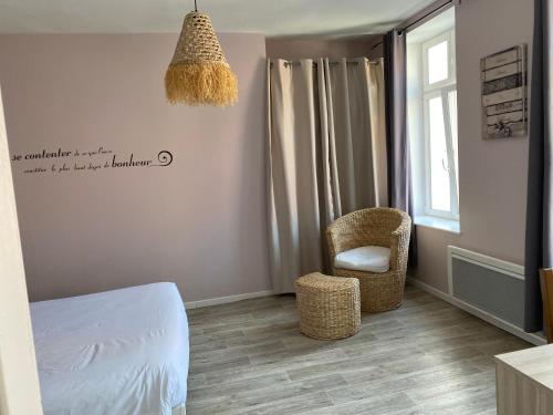 a bedroom with a bed and a chair and a window at Gites de la Haute Ville in Boulogne-sur-Mer