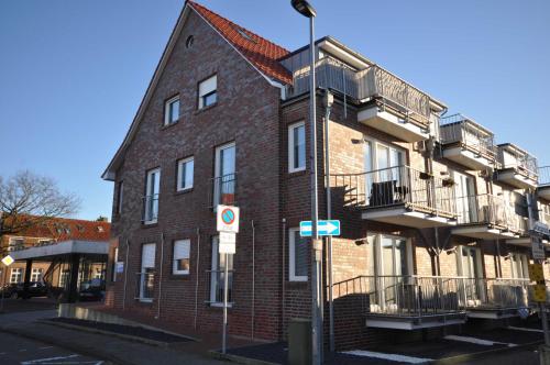 a red brick building with balconies on a street at Nr 57 - Ferienwohnung Mühlenstraße in Carolinensiel