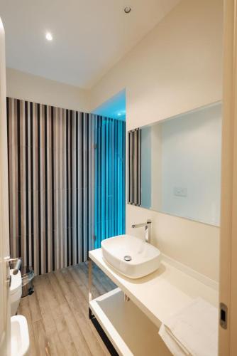 a white bathroom with a sink and a mirror at Appartamento in Piazza a Bevagna in Bevagna