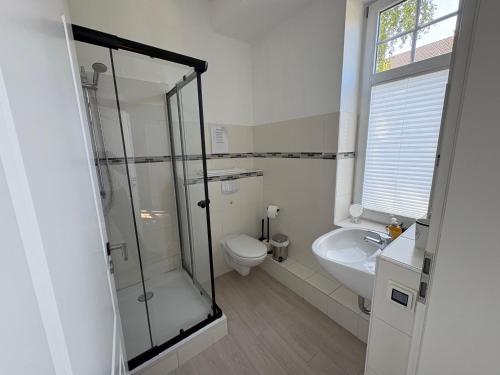 a bathroom with a shower and a toilet and a sink at Seehaus Plön in Plön