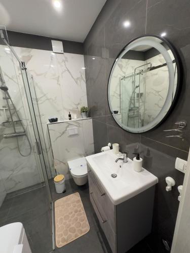 a bathroom with a sink and a shower and a mirror at SeaView Apartment Toni in Milna
