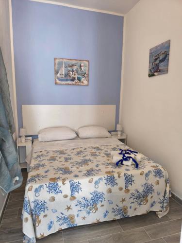 a bedroom with a bed with a blue and white comforter at New Casa bluchic in Isola delle Femmine