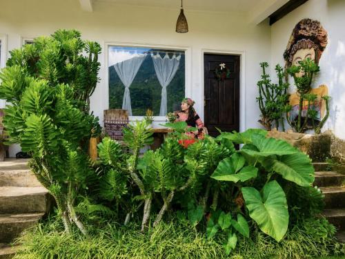 a woman sitting at a table in a house with plants at Lagom home - Cactus in Sapa
