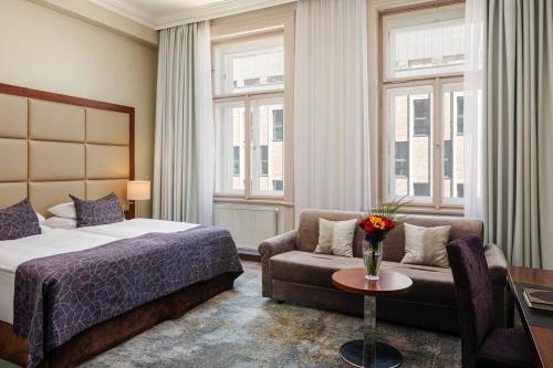 a hotel room with a bed and a couch at Kosher Hotel King David Prague in Prague