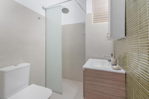 a bathroom with a toilet and a sink and a shower at Dorothy's Seaview Apartment in Haraki