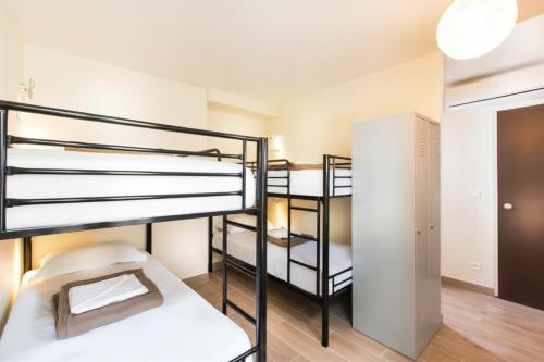 a room with three bunk beds and a closet at Enjoy Hostel in Paris