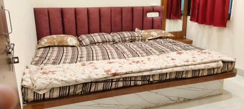 a bedroom with a bed with a red headboard and pillows at Hotel shivansh in Godarpura