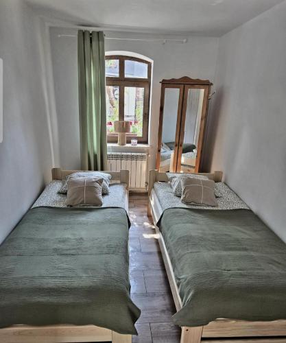 zwei Betten in einem Zimmer mit Fenster in der Unterkunft Gordonówka in Choszczno