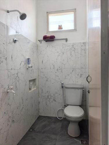 a bathroom with a toilet and a shower at Santalum Hotel Yogyakarta in Yogyakarta
