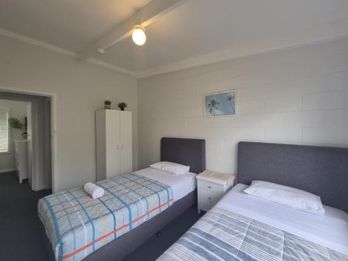 a bedroom with two beds and a refrigerator at Esperance Little Units 3 in Esperance