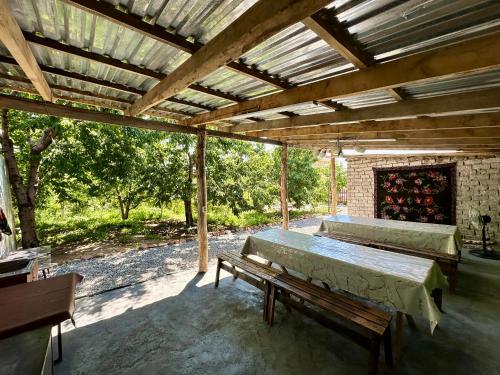 two beds in a pavilion with a bench on a patio at Nomad Garden Camp in Cholpon-Ata