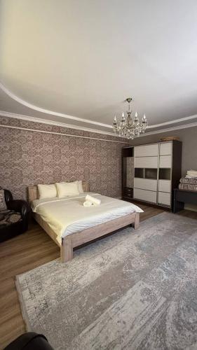 a bedroom with a large bed and a chandelier at Eneshka- дача in Dolinka