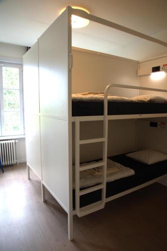 a room with bunk beds and a closet at HI Hostel Dunepanne in De Haan