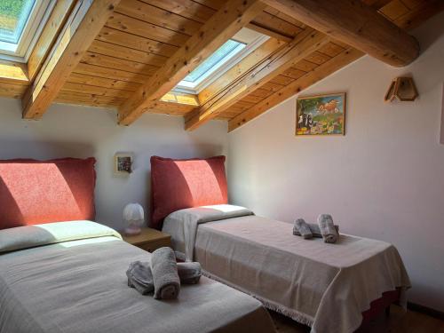 a bedroom with two beds with slippers on them at Dimora Ceramont, Rizzolaga Ospitar in Baselga di Pinè