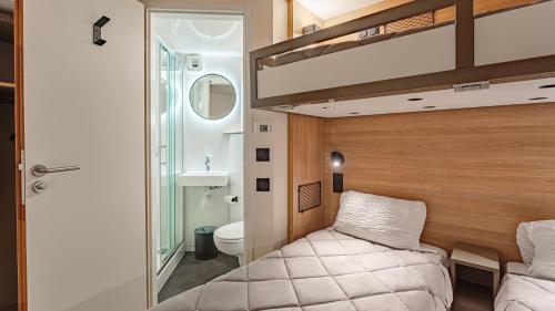 a small bedroom with a bed and a bathroom at Premiere Classe Biarritz in Biarritz