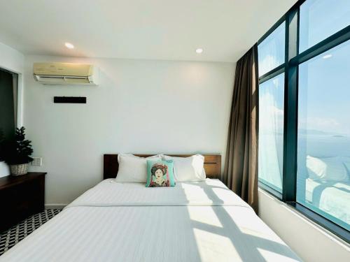 a bedroom with a bed with a large window at Nomad Apartment in Nha Trang