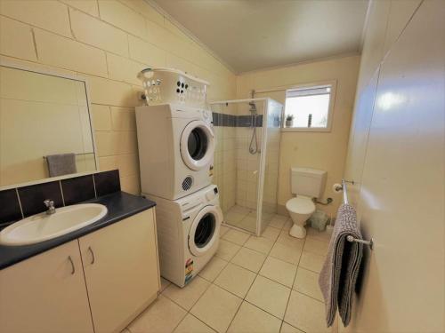 a bathroom with a washing machine and a sink at Esperance Little Units 2 in Esperance