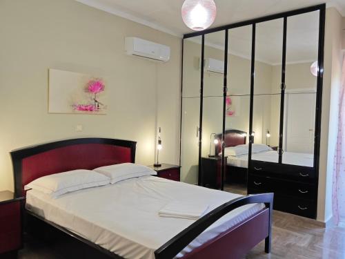 a bedroom with a large bed and a mirror at Christina's Cottage in Agios Nikolaos