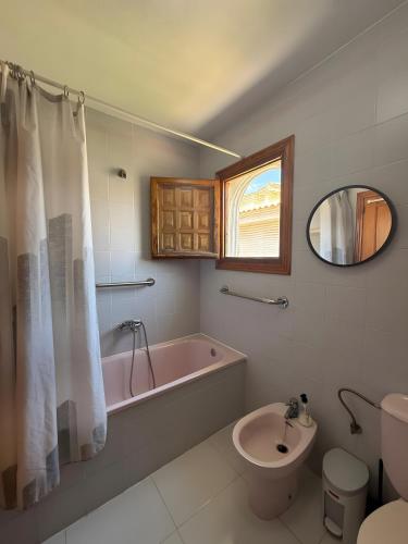a bathroom with a tub and a toilet and a sink at Casa en la playa con piscinas in Gran Alacant