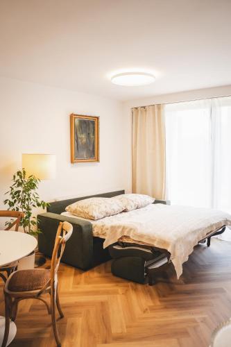 a bedroom with a bed and a table and chairs at Pioneer house - app with free parking place, terrace and private garden in Koliba