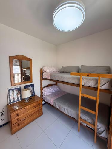 a bedroom with two bunk beds and a mirror at Casa en la playa con piscinas in Gran Alacant