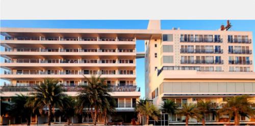 a large building with palm trees in front of it at Regenta Waterfront Resort, Dapoli in Dapoli