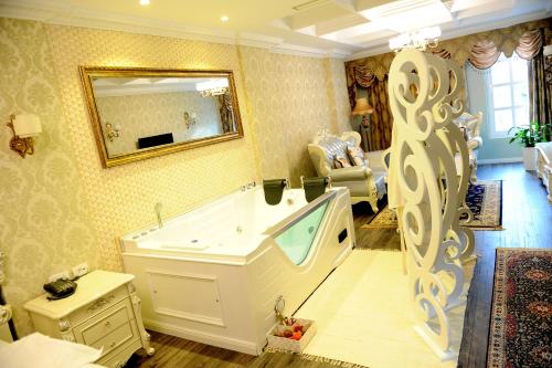 a large bathroom with a tub and a mirror at Hotel Britania in Tirana