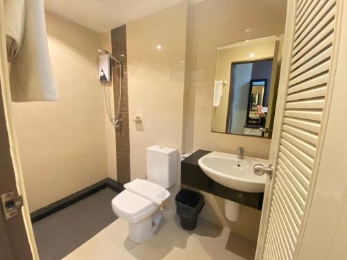 a bathroom with a toilet and a sink and a mirror at Leelawadee Modern Resort Huaykwang - ลีลาวดี ห้วยขวาง in Bangkok