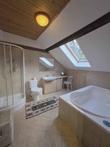 a bathroom with a tub and a toilet and a sink at Stawy Karłowo in Karłowo