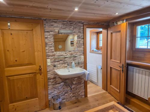 a bathroom with a sink and a stone wall at Pension Monteneu in Bartholomäberg