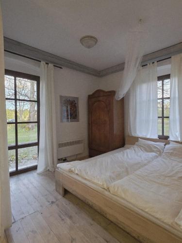 a bedroom with a large white bed with windows at Stawy Karłowo in Karłowo