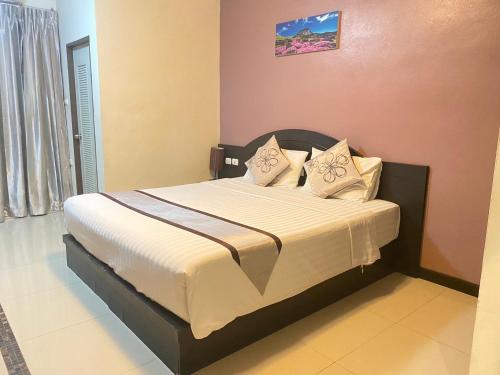 a bedroom with a bed with white sheets and pillows at Leelawadee Modern Resort Huaykwang - ลีลาวดี ห้วยขวาง in Bangkok