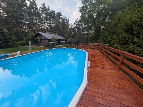 a swimming pool on the deck of a house at Dom wakacyjny i Domki letniskowe nad Tanwią Roztocze in Narol