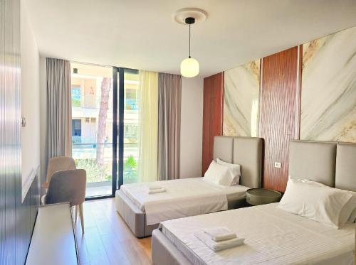 a hotel room with two beds and a window at Seaside Premium Villa in Lalzit Bay