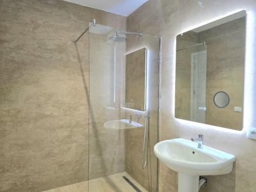 a bathroom with a sink and a glass shower at Seaside Premium Villa in Lalzit Bay