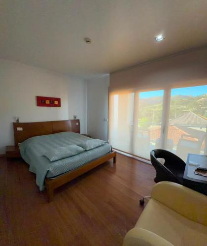 ein Schlafzimmer mit einem Bett, einem Stuhl und einer Couch in der Unterkunft Hotel De Cerva in Cerva