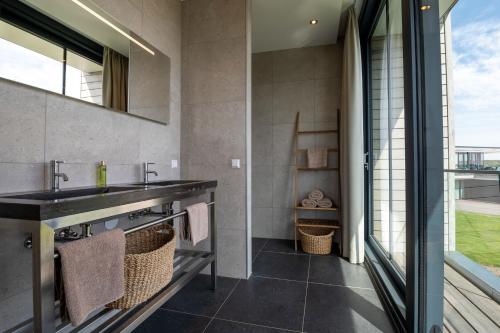 a bathroom with a sink and a mirror at Dormio Harbour Village in Arnemuiden