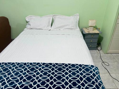 a bedroom with a bed with a blue and white comforter at Ava s Cozy Studio in Tunbridge