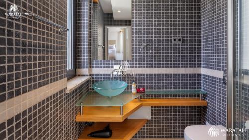 a bathroom with a glass bowl sink on a glass table at Emily in Vale do Lobo