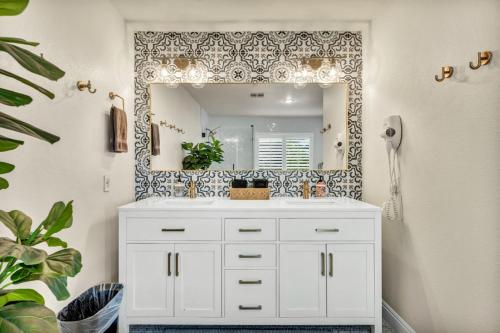 a bathroom with a white sink and a mirror at Luxury and Harmony in a 6BR Dream Villa; Pool, Hot Tub, Game room, Near the Las Vegas Strip in Las Vegas