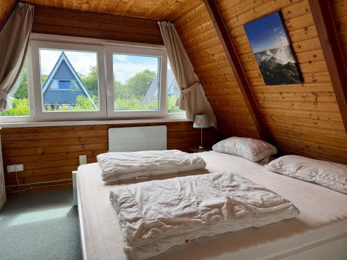 two beds in a room with two windows at Ferienhaus Seemöwe in Damp